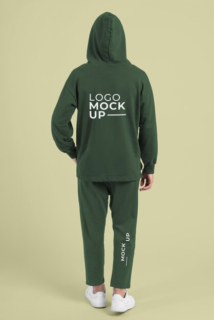 Uomo che indossa pantaloni da jogging e mockup di felpa con cappuccio