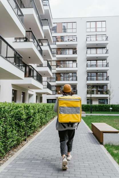 a man wearing a yellow safety vest walks down a sidewalk