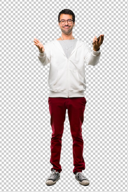 Man with glasses and listening music presenting and inviting to come with hand. Happy that you came