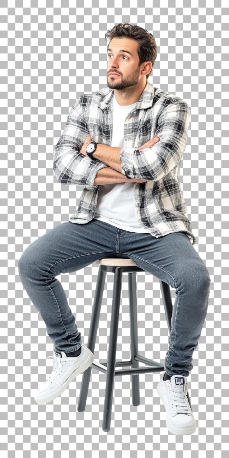 a man with his arms crossed sitting on a stool