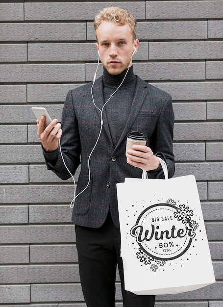 PSD man with shopping bags and holding mobile