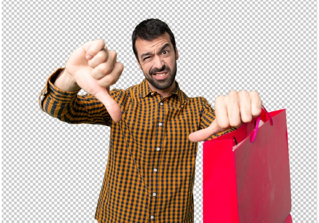 Man with shopping bags showing thumb down with both hands