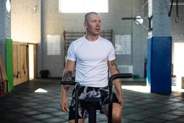 man working out in a gym using an air bike