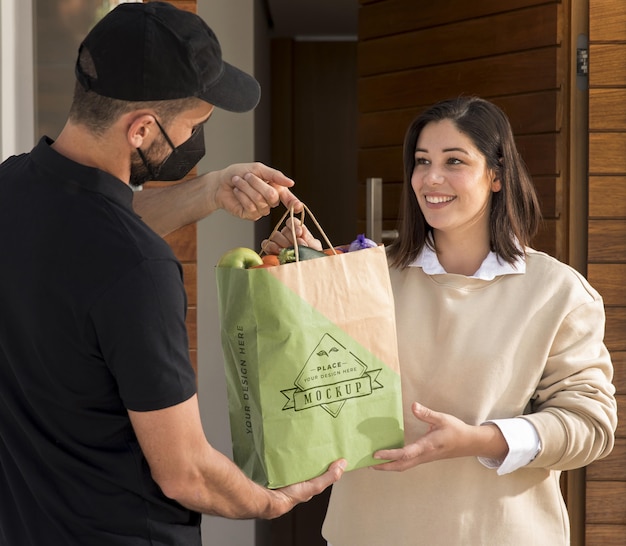 PSD medium shot delivery man holding bag