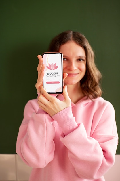 Medium shot girl holding smartphone