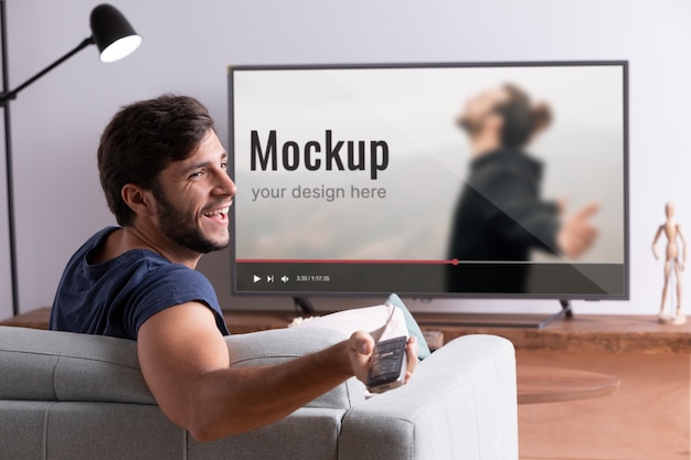 Medium shot smiley man watching movie on tv