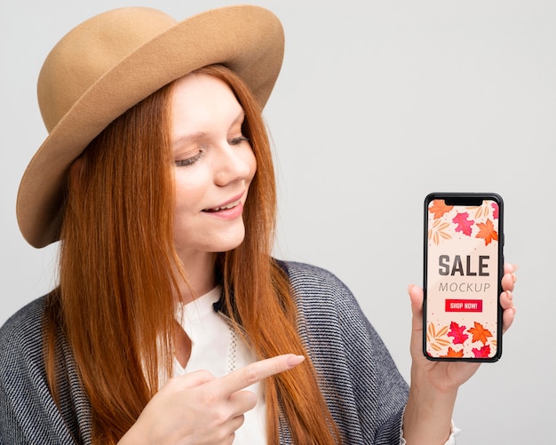 Medium shot woman pointing at phone