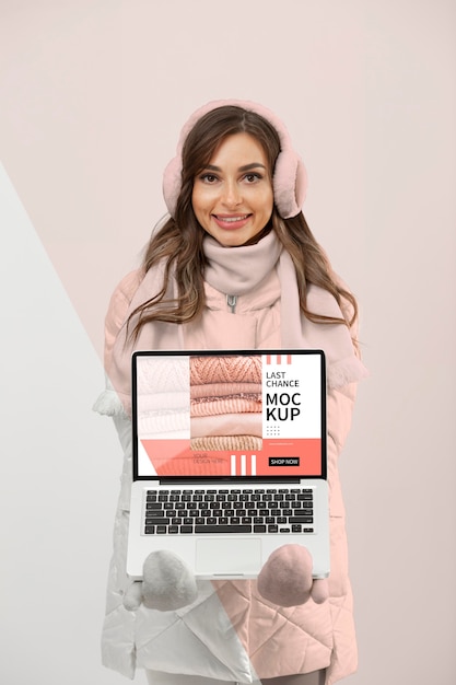 Medium shot woman with warm clothes and laptop