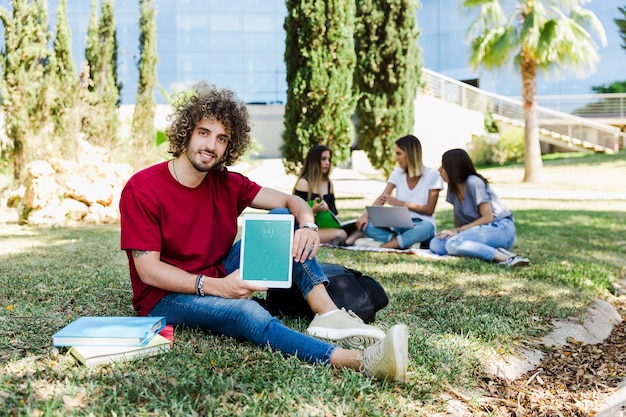 Mens die tabletmodel in park toont