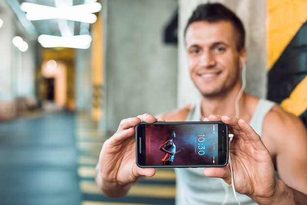 Mens in smartphone van de gymnastiekholding model