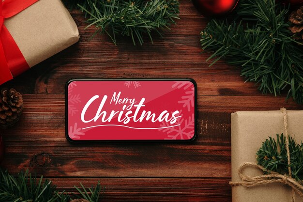 クリスマスプレゼントの装飾が施されたメリークリスマススマートフォンのモックアップ
