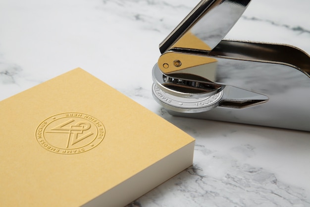 PSD metallic stamp with embossed logo effect on paper