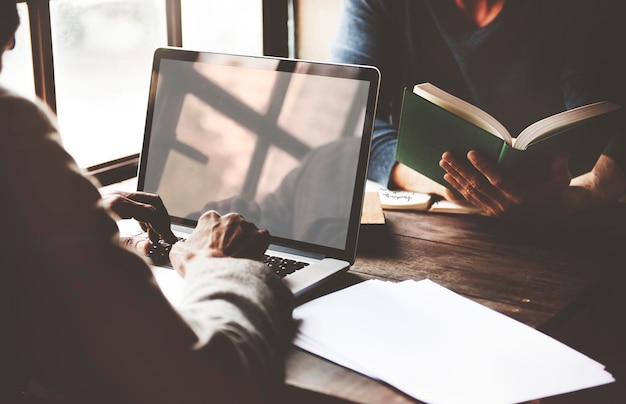 Mężczyzna siedzący przy oknie i pracujący na laptopie