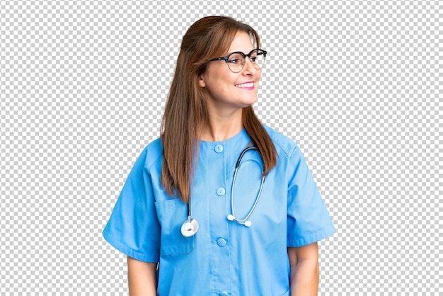 Middle age nurse woman over isolated background looking side