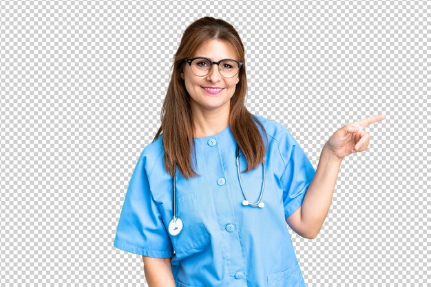 Middle age nurse woman over isolated background pointing finger to the side