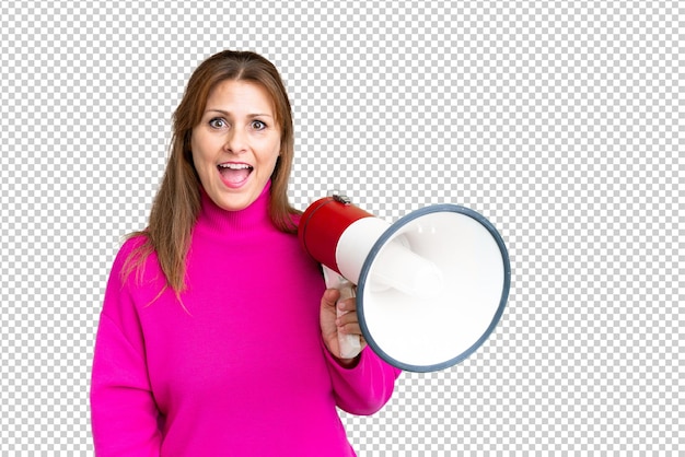 PSD middle age woman over isolated background holding a megaphone and with surprise expression