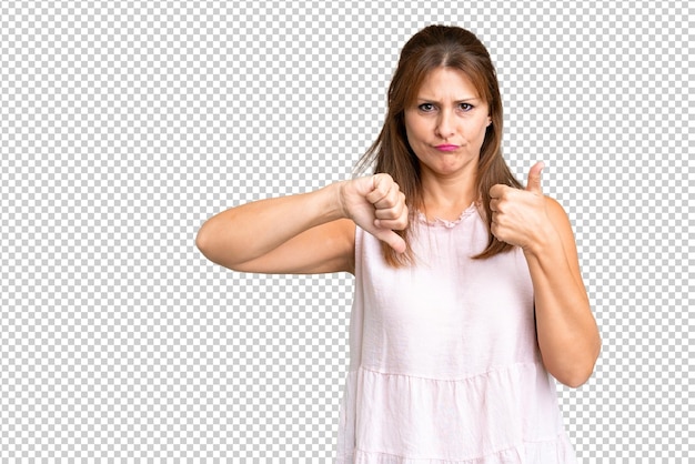 PSD middle age woman over isolated background making goodbad sign undecided between yes or not