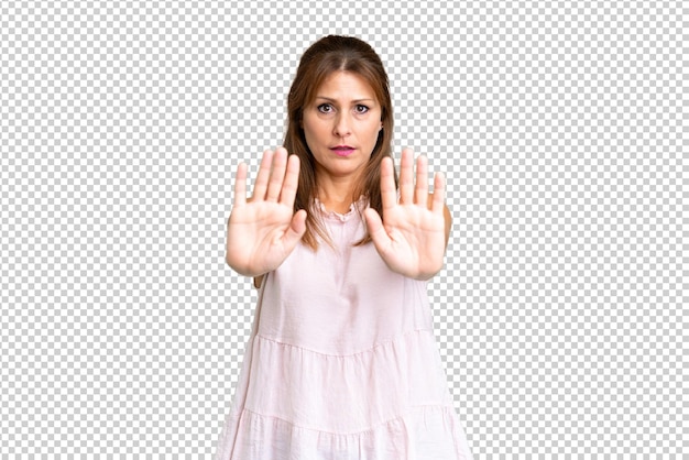 Middle age woman over isolated background making stop gesture and disappointed