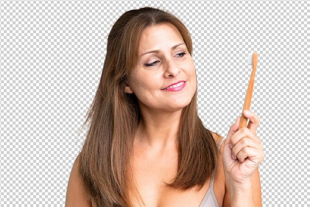 PSD middle age woman over isolated background with a toothbrush