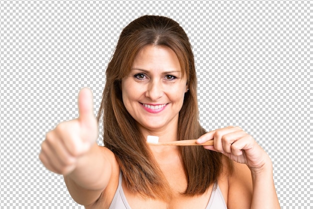 Middle age woman over isolated background with a toothbrush
