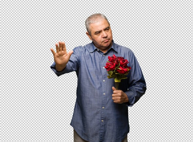 Uomo di mezza età festeggia il giorno di san valentino mettendo la mano davanti