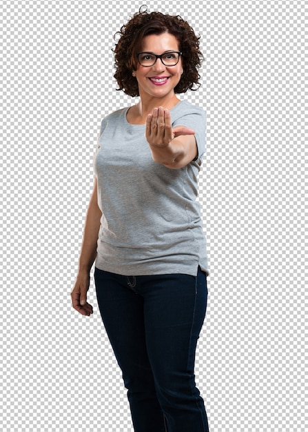 Middle aged woman inviting to come, confident and smiling making a gesture with hand, being positive and friendly