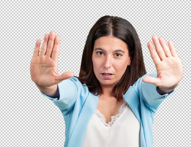 middle aged woman serious and determined, putting hand in front, stop gesture, deny concept
