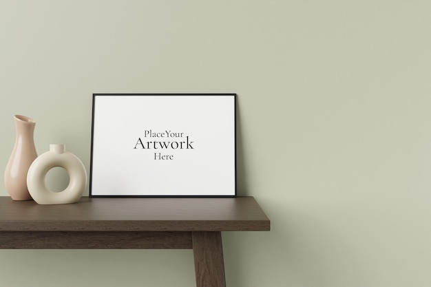 Minimalist and clean horizontal black poster or photo frame mockup on the wooden table leaning against the room wall with decorative vase