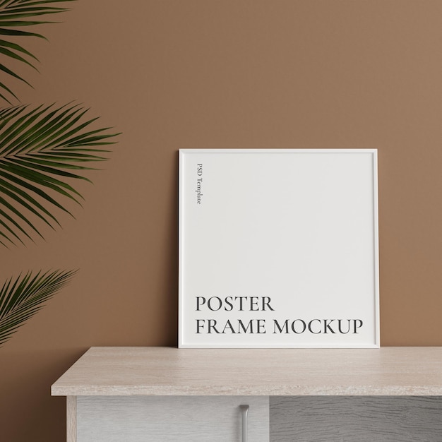Minimalist front view square white photo or poster frame mockup leaning against wall on table with plant 3d rendering