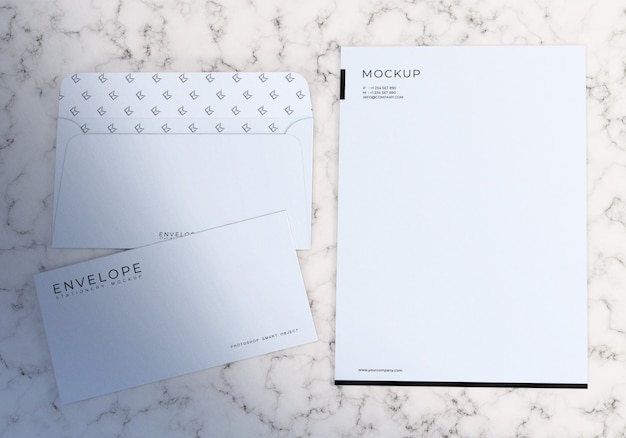 Busta bianca minimalista e carta intestata set mockup con sfondo di marmo bianco