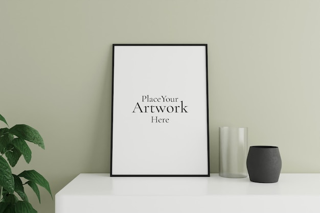 Minimalistyczny i czysty pionowy czarny plakat lub makieta ramki na zdjęcia na białym stole opartym o ścianę pokoju z wazonem i rośliną