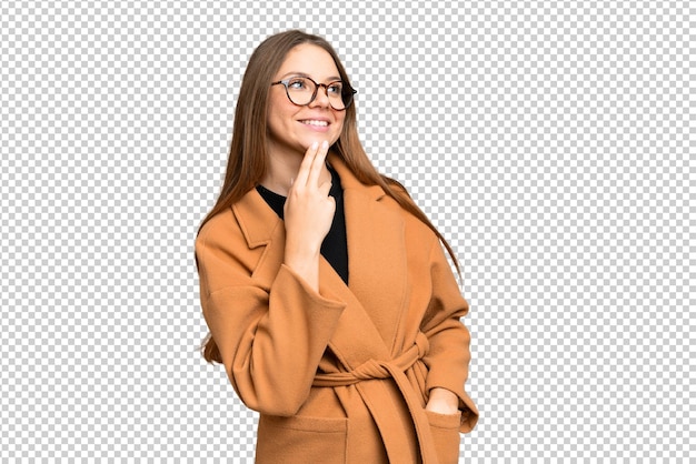 Młoda blondynka na izolowanym tle chroma key patrzy w górę uśmiechając się