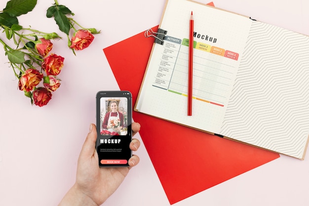 PSD mobile beside agenda and flowers on desk