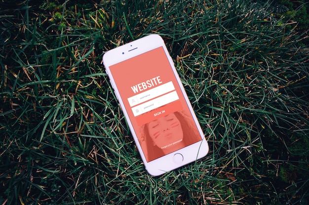 PSD mobile phone on grass mock up