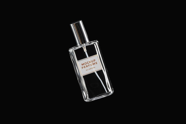 PSD mock-up of clear bottle of perfume on black background