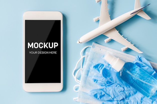 Mock up di smartphone con modello di aereo, maschera e disinfettante.