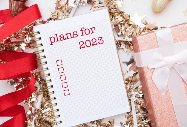 Mock up van kladblok of schrijfboek met geschreven tekst - plannen voor 2023. Selectievakje om te doen
