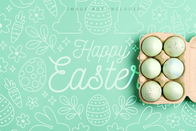 mockup-ansichtkaart met papiercontainer met geschilderde groene eieren op een groene kleur oppervlak, Happy Easter-concept.