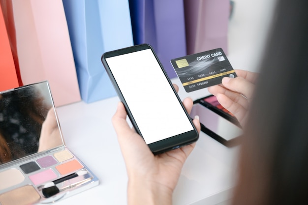 Mockup of beautiful woman holding credit card shopping online with smartphone on online websites