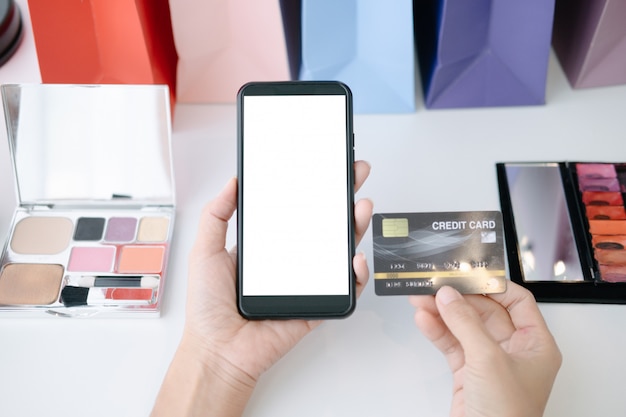 PSD mockup of beautiful woman holding credit card shopping online with smartphone on online websites