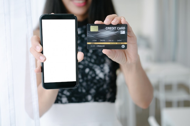 PSD mockup of beautiful woman holding credit card shopping online with smartphone on online websites