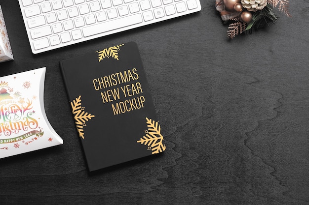 PSD mockup black cover notebook on black wood for christmas new year