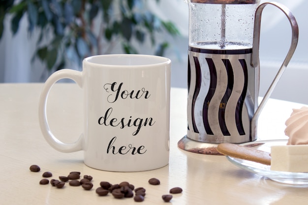 Mockup of a Coffee mug on a table with sweets and french-press