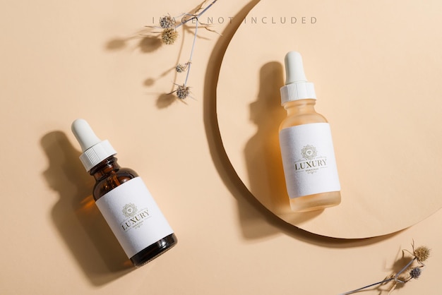 Mockup cosmetic bottles with a dropper on a beige surface with bright sunlight and hard shadows.