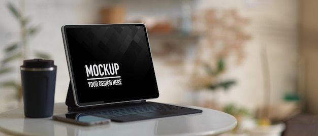 Mockup digital tablet with keyboard and coffee cup on coffee table