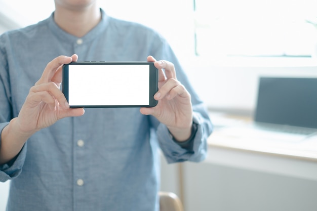 PSD mockup of engineers showing smartphone design building project in office