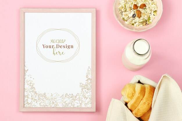 Mockup foto frame op roze achtergrond met muesli, croissant en een fles melk