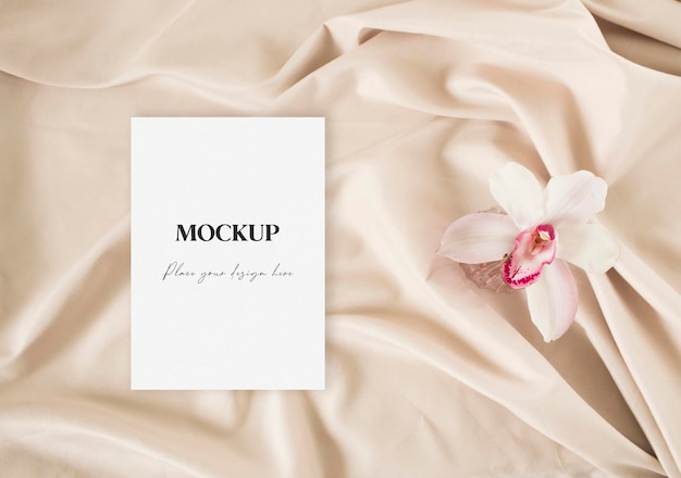 Mockup greeting card with lily on the nude fabric background