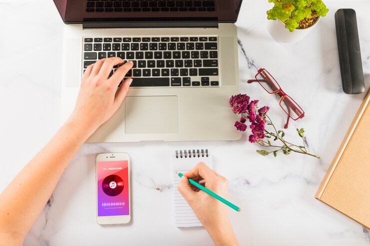 PSD mockup of hand writing on notepad with laptop and smartphone