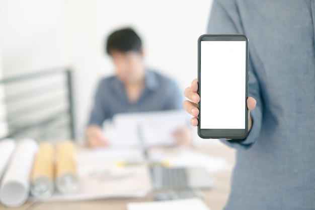 Mockup image of engineers showing smartphone design building Project in office